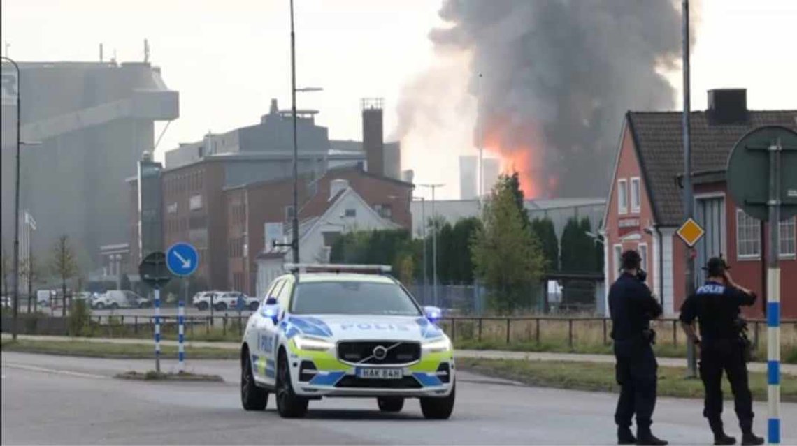 Politifolk i beskyttelsesmasker overvåker batteribrannen. Foto: Skjermdump video TV4 Politifolk i beskyttelsesmasker overvåker batteribrannen. Foto: Skjermdump video TV4