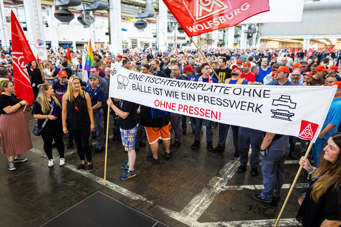 Employees protest before the start of a works meeting in a hall at the VW plant in Wolfsburg, Germany, Wednesday, Sept. 4, 2024. Volkswagen has announced that it will tighten its austerity measures due to the tense situation of the core brand. Even compulsory redundancies and plant closures could no longer be ruled out. (Moritz Frankenberg/dpa via AP) Employees protest before the start of a works meeting in a hall at the VW plant in Wolfsburg, Germany, Wednesday, Sept. 4, 2024. Volkswagen has announced that it will tighten its austerity measures due to the tense situation of the core brand. Even compulsory redundancies and plant closures could no longer be ruled out. (Moritz Frankenberg/dpa via AP)