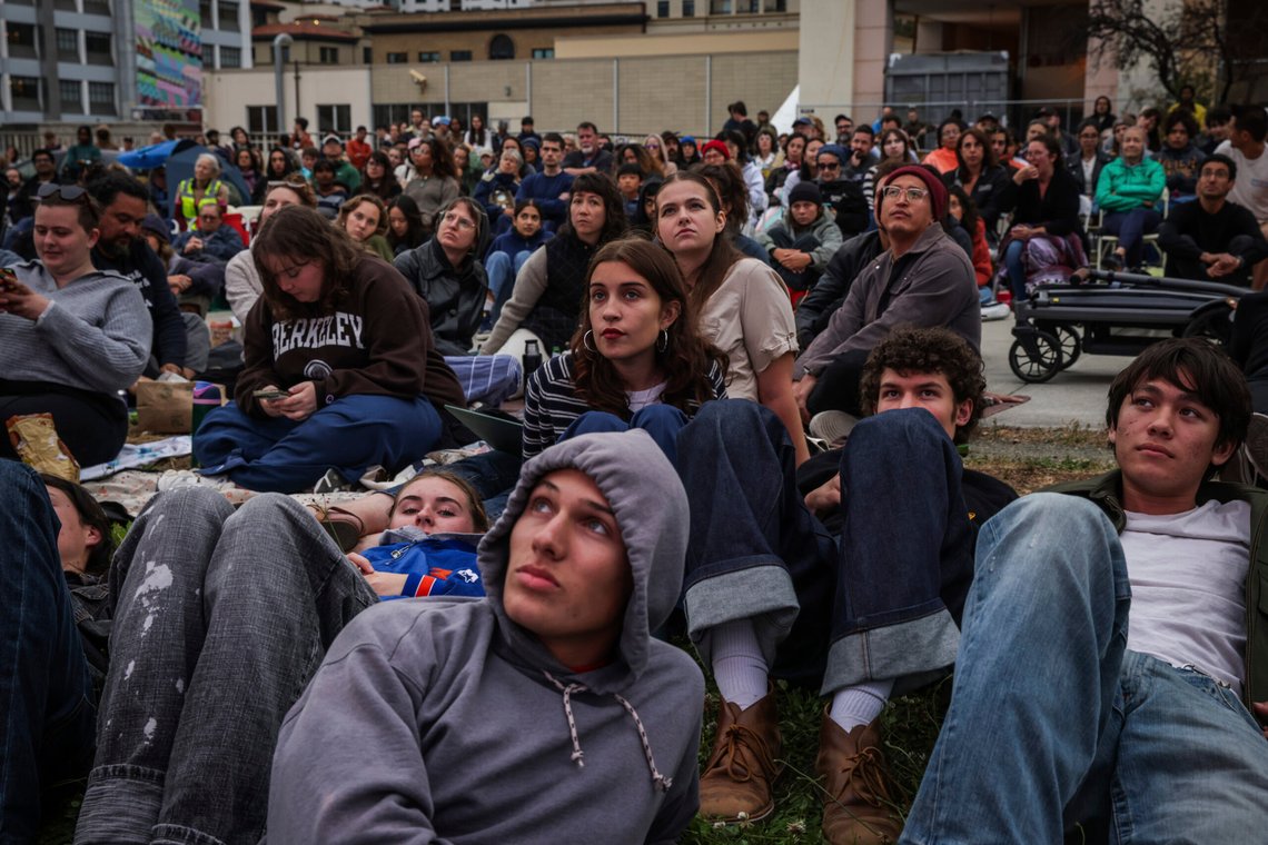 Cooper Walts, bottom center, lays on the grass as he watches a presidential debate between Republican presidential nominee former President Donald Trump and Democratic presidential nominee Vice President Kamala Harris at the Berkeley Art Museum and Pacific Film Archive watch party in Berkeley, Calif., Tuesday, Sept. 10, 2024. (Gabrielle Lurie/San Francisco Chronicle via AP) Cooper Walts, bottom center, lays on the grass as he watches a presidential debate between Republican presidential nominee former President Donald Trump and Democratic presidential nominee Vice President Kamala Harris at the Berkeley Art Museum and Pacific Film Archive watch party in Berkeley, Calif., Tuesday, Sept. 10, 2024. (Gabrielle Lurie/San Francisco Chronicle via AP)