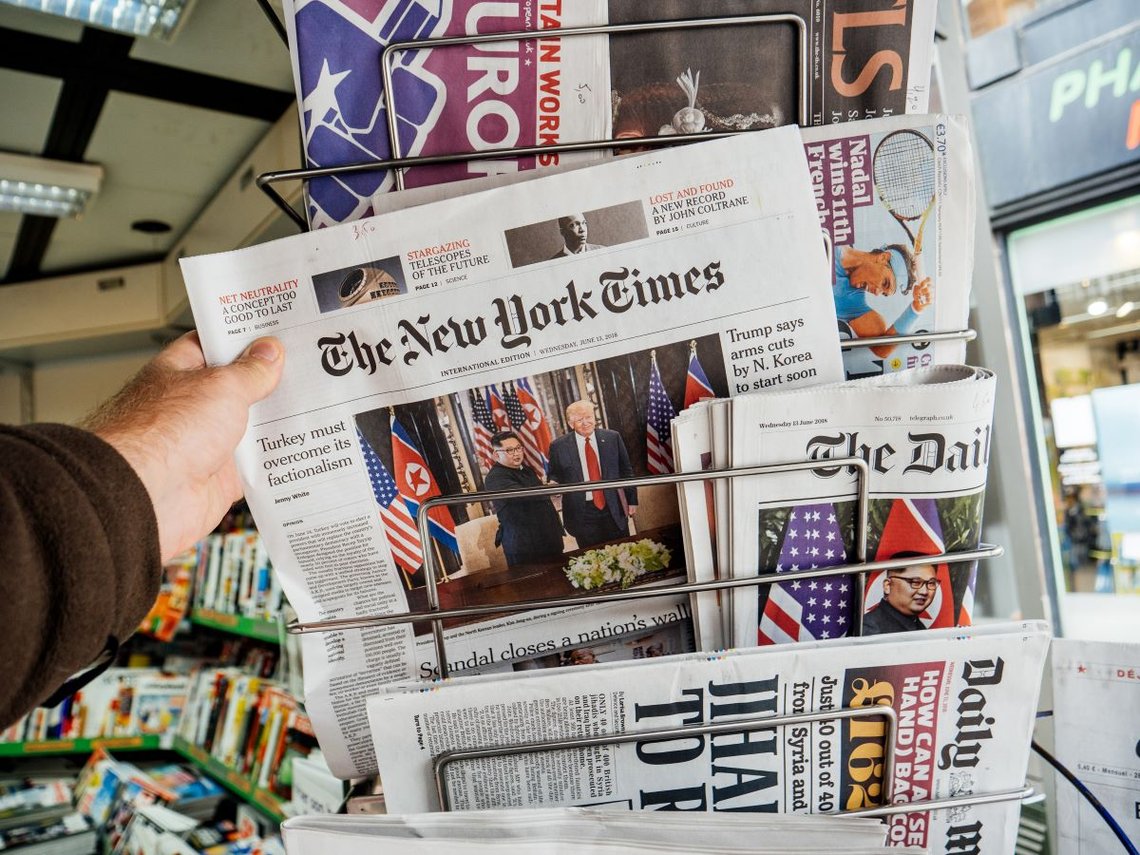 Paris, Frankrike, juni 2018: En mann kjøper avisen The New York Times i en pressekiosk med USAs president Donald Trump som møter Nord-Koreas leder Kim Jong-un i Singapore. Foto: Shutterstock av Hadrian. Paris, Frankrike, juni 2018: En mann kjøper avisen The New York Times i en pressekiosk med USAs president Donald Trump som møter Nord-Koreas leder Kim Jong-un i Singapore. Foto: Shutterstock av Hadrian.