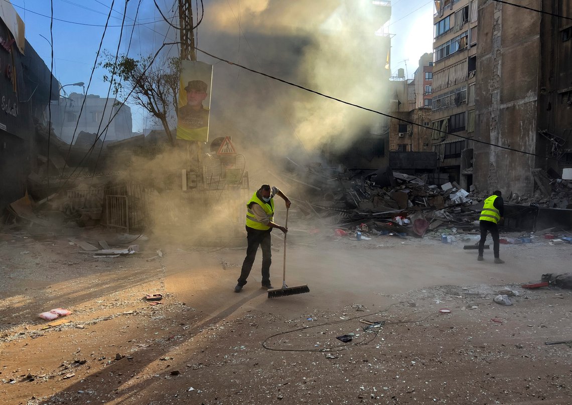 Workers clean a street as smoke rises from a destroyed building that was hit by an Israeli airstrike in Dahiyeh, in the southern suburb of Beirut, Lebanon, early Sunday, Oct. 20, 2024. (AP Photo/Hussein Malla) Workers clean a street as smoke rises from a destroyed building that was hit by an Israeli airstrike in Dahiyeh, in the southern suburb of Beirut, Lebanon, early Sunday, Oct. 20, 2024. (AP Photo/Hussein Malla)