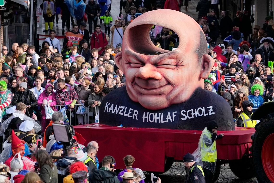 A carnival float depicts German chancellor Olaf Scholz with a hole in his head during the traditional carnival parade in Duesseldorf, Germany, on Monday, Feb. 12, 2024. The foolish street spectacles in the carnival centers of Duesseldorf, Mainz and Cologne, watched by hundreds of thousands of people, are the highlights in Germany's carnival season on Rosemonday. (AP Photo/Martin Meissner) A carnival float depicts German chancellor Olaf Scholz with a hole in his head during the traditional carnival parade in Duesseldorf, Germany, on Monday, Feb. 12, 2024. The foolish street spectacles in the carnival centers of Duesseldorf, Mainz and Cologne, watched by hundreds of thousands of people, are the highlights in Germany's carnival season on Rosemonday. (AP Photo/Martin Meissner)