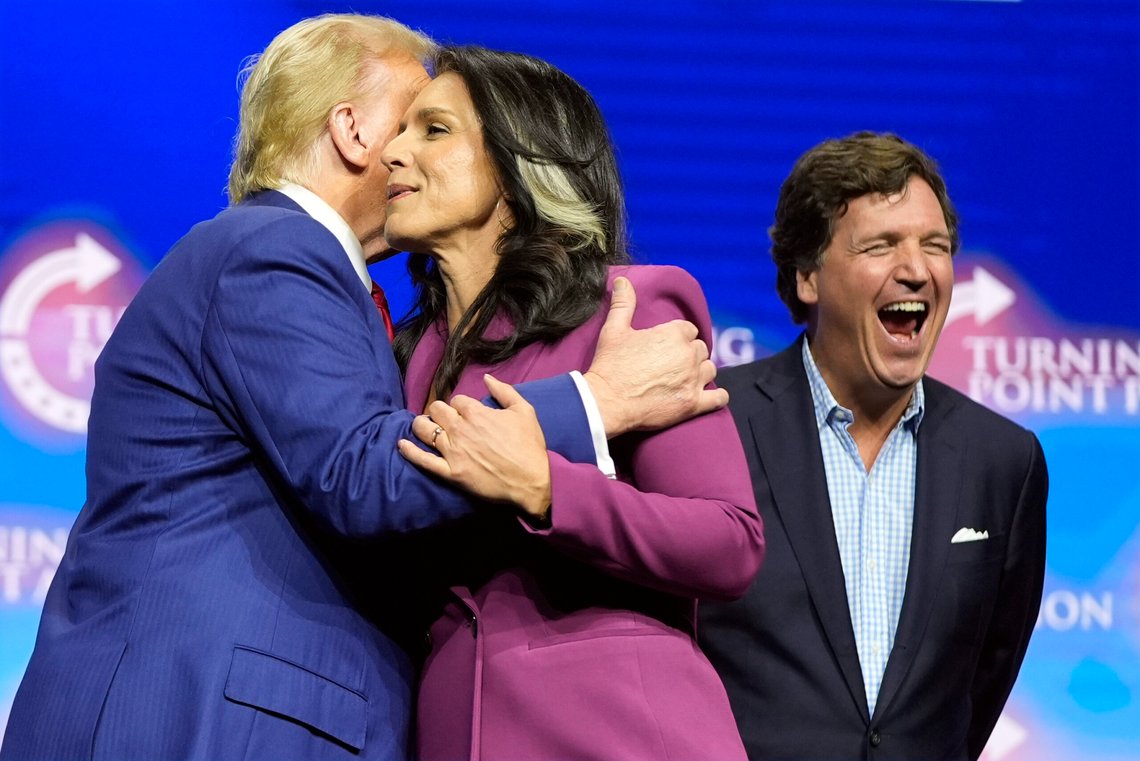Former Democratic Rep. Tulsi Gabbard hugs Republican presidential nominee former President Donald Trump as Tucker Carlson yells during a campaign rally Wednesday, Oct. 23, 2024, in Duluth, Ga. (AP Photo/Alex Brandon) Former Democratic Rep. Tulsi Gabbard hugs Republican presidential nominee former President Donald Trump as Tucker Carlson yells during a campaign rally Wednesday, Oct. 23, 2024, in Duluth, Ga. (AP Photo/Alex Brandon)