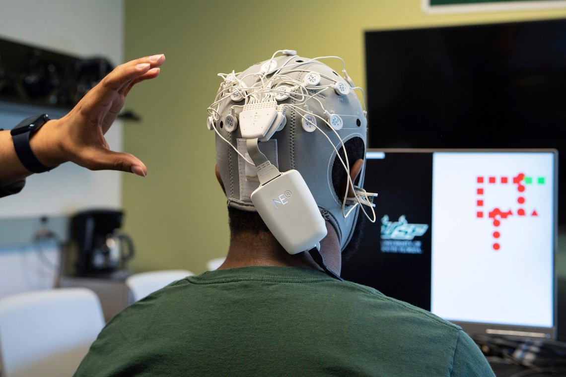 Marvin Andujar, assistant professor and director of the Neuro-Machine Interaction Lab at the University of South Florida, explains how Tyree Lewis, a USF Ph.D. student, is able to brain-paint through emerging brain-computer interface (BCI) technology on Wednesday, June 15, 2022, at USF in Tampa, Fla. Andujar said the technology can be used to improve attention overtime in participants with ADHD, as the technology requires participants full attention and concentration to create images with the mind. (Angelica Edwards/Tampa Bay Times via AP) Marvin Andujar, assistant professor and director of the Neuro-Machine Interaction Lab at the University of South Florida, explains how Tyree Lewis, a USF Ph.D. student, is able to brain-paint through emerging brain-computer interface (BCI) technology on Wednesday, June 15, 2022, at USF in Tampa, Fla. Andujar said the technology can be used to improve attention overtime in participants with ADHD, as the technology requires participants full attention and concentration to create images with the mind. (Angelica Edwards/Tampa Bay Times via AP)