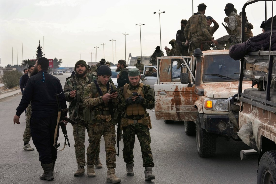 Syrian fighters check their mobiles, as they patrol a highway in Damascus, Syria, Thursday, Dec. 26, 2024. (AP Photo/Hussein Malla) Syrian fighters check their mobiles, as they patrol a highway in Damascus, Syria, Thursday, Dec. 26, 2024. (AP Photo/Hussein Malla)