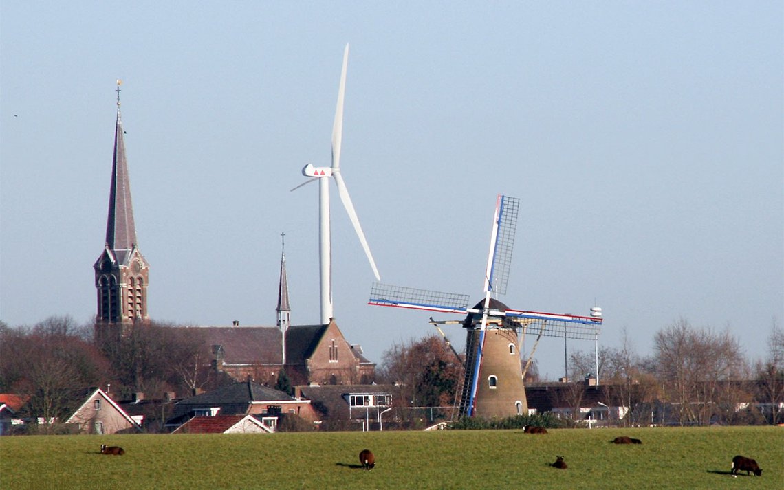 Mølle med kuer, kirke og vindturbin i Den Hout, en landsby i provinsen Nord-Brabant, Nederland. Foto: Quistnix CC-BY-SA-2.5 Mølle med kuer, kirke og vindturbin i Den Hout, en landsby i provinsen Nord-Brabant, Nederland. Foto: Quistnix CC-BY-SA-2.5