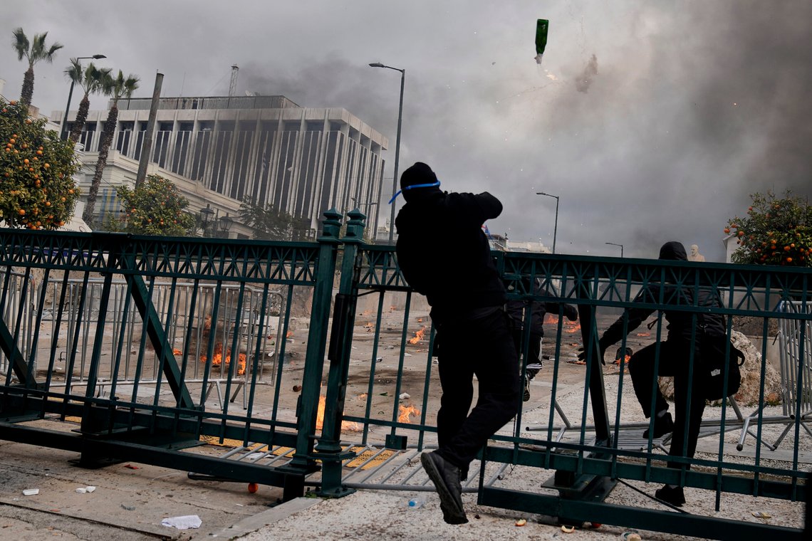 En demonstrant kaster en brannbombe mot opprørspoliti utenfor nasjonalforsamlingen i Aten. Det var massedemonstrasjon og streik i Hellas fredag, der mange krever svar om den katastrofale togulykken i landet i februar 2023. Foto: Petros Giannakouris / AP / NTB En demonstrant kaster en brannbombe mot opprørspoliti utenfor nasjonalforsamlingen i Aten. Det var massedemonstrasjon og streik i Hellas fredag, der mange krever svar om den katastrofale togulykken i landet i februar 2023. Foto: Petros Giannakouris / AP / NTB