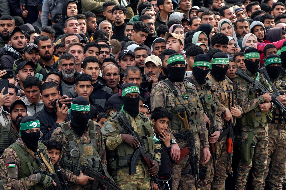 Palestinians watch as Hamas fighters stand in formation ahead of a hostages release in Deir al-Balah, central Gaza Strip, Saturday Feb. 8, 2025. (AP Photo/Abdel Kareem Hana) Palestinians watch as Hamas fighters stand in formation ahead of a hostages release in Deir al-Balah, central Gaza Strip, Saturday Feb. 8, 2025. (AP Photo/Abdel Kareem Hana)