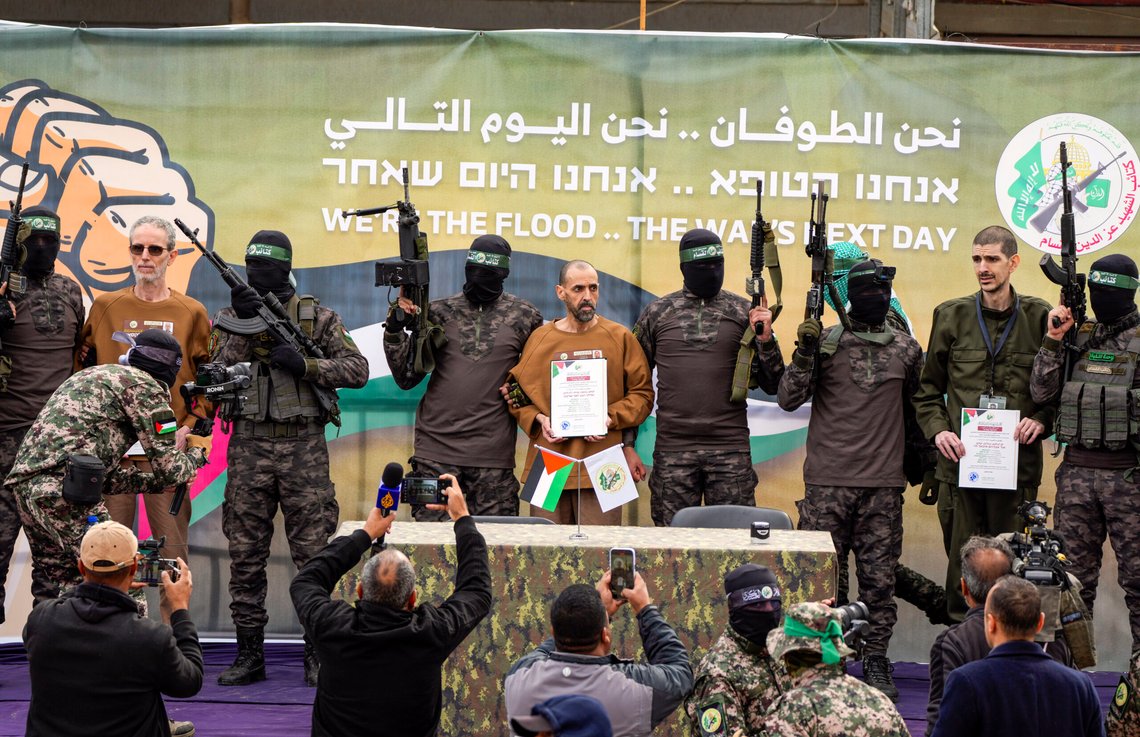 Israeli captives, from left to the right, Ohad Ben Ami, Eli Sharabi and Or Levy, who have been held hostage by Hamas in Gaza since October 7, 2023, satnd escorted by Hamas fighters on a stage before being handed over to the Red Cross in Deir al-Balah, central Gaza Strip, Saturday Feb. 8, 2025. (AP Photo/Abdel Kareem Hana) Israeli captives, from left to the right, Ohad Ben Ami, Eli Sharabi and Or Levy, who have been held hostage by Hamas in Gaza since October 7, 2023, satnd escorted by Hamas fighters on a stage before being handed over to the Red Cross in Deir al-Balah, central Gaza Strip, Saturday Feb. 8, 2025. (AP Photo/Abdel Kareem Hana)