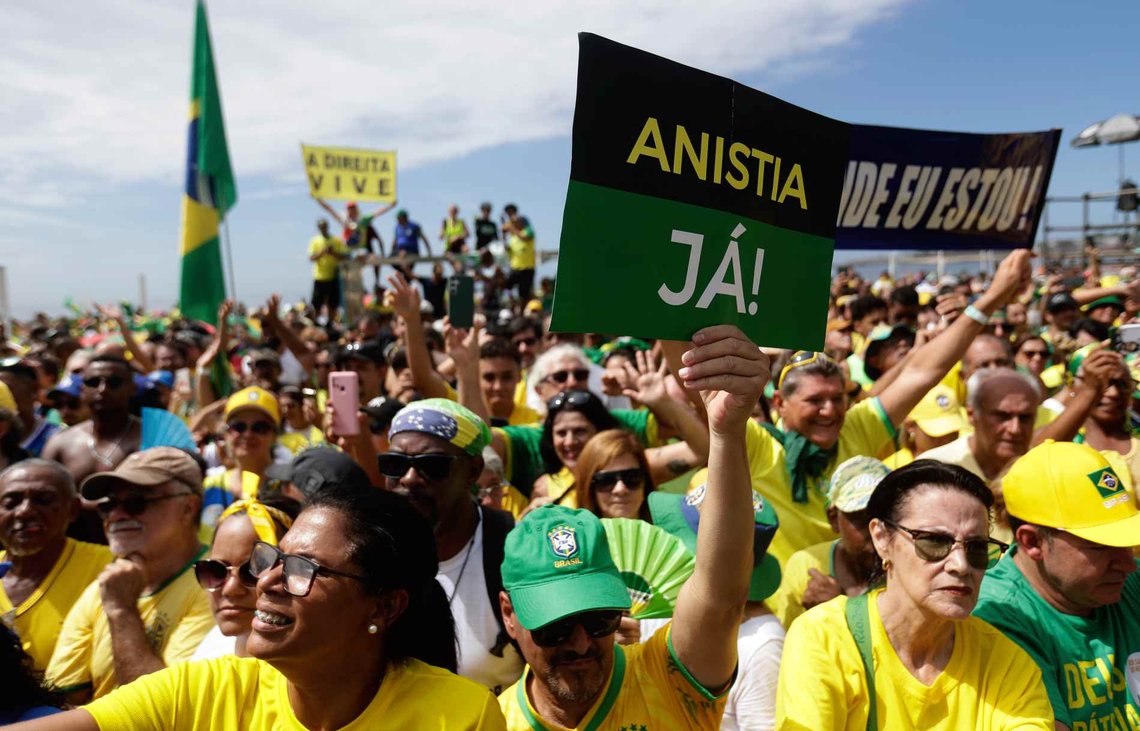 En tilhenger av tidligere president Jair Bolsonaro holder opp et skilt med teksten «Amnesti nå» under en massemønstring på Copacabana-stranden i Rio de Janeiro i helgen. (Foto: Bruna Prado/AP) En tilhenger av tidligere president Jair Bolsonaro holder opp et skilt med teksten «Amnesti nå» under en massemønstring på Copacabana-stranden i Rio de Janeiro i helgen. (Foto: Bruna Prado/AP)