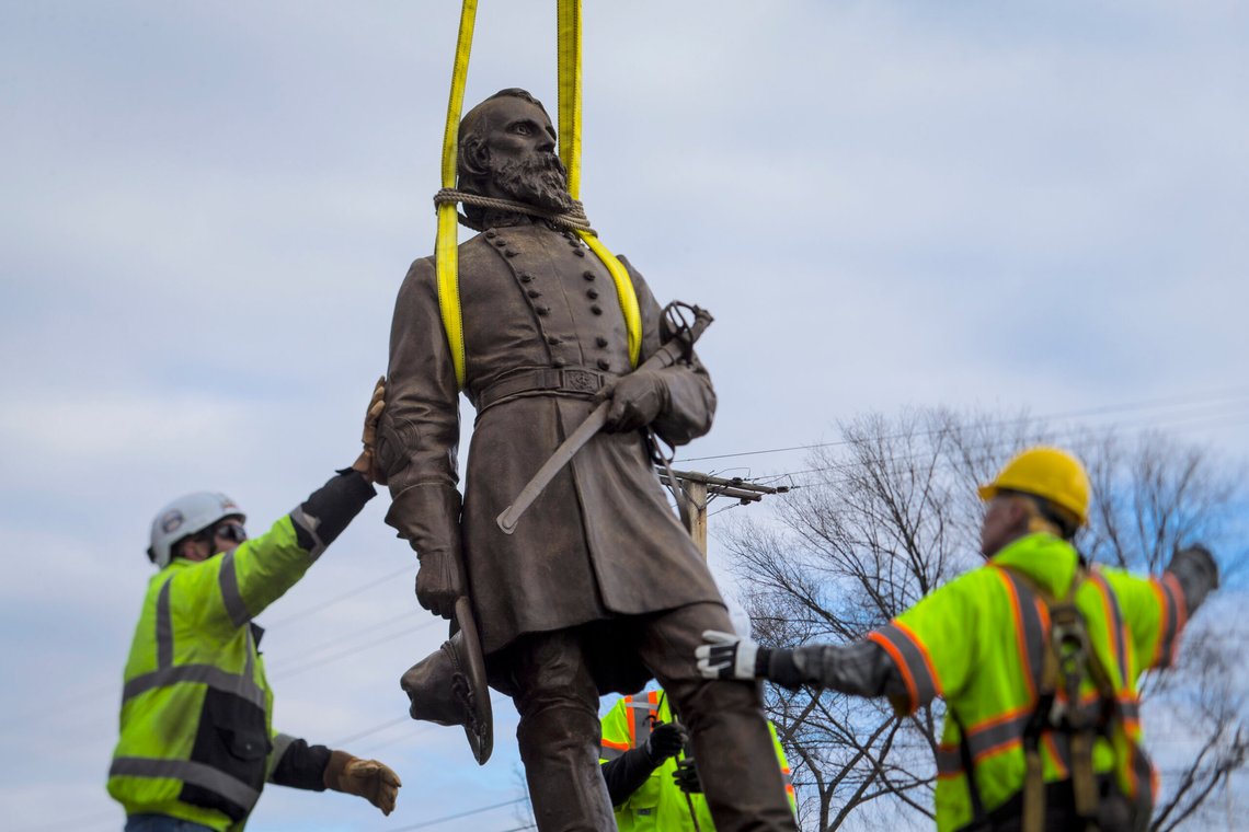 Workers begin to lay the bronze statue of Confederate General A.P. Hill onto a flatbed truck on Monday Dec. 12, 2022 in Richmond, Va. Workers are still planning to exhume the remains of General Hill which located inside the base of the statue. (AP Photo/John C. Clark) Workers begin to lay the bronze statue of Confederate General A.P. Hill onto a flatbed truck on Monday Dec. 12, 2022 in Richmond, Va. Workers are still planning to exhume the remains of General Hill which located inside the base of the statue. (AP Photo/John C. Clark)