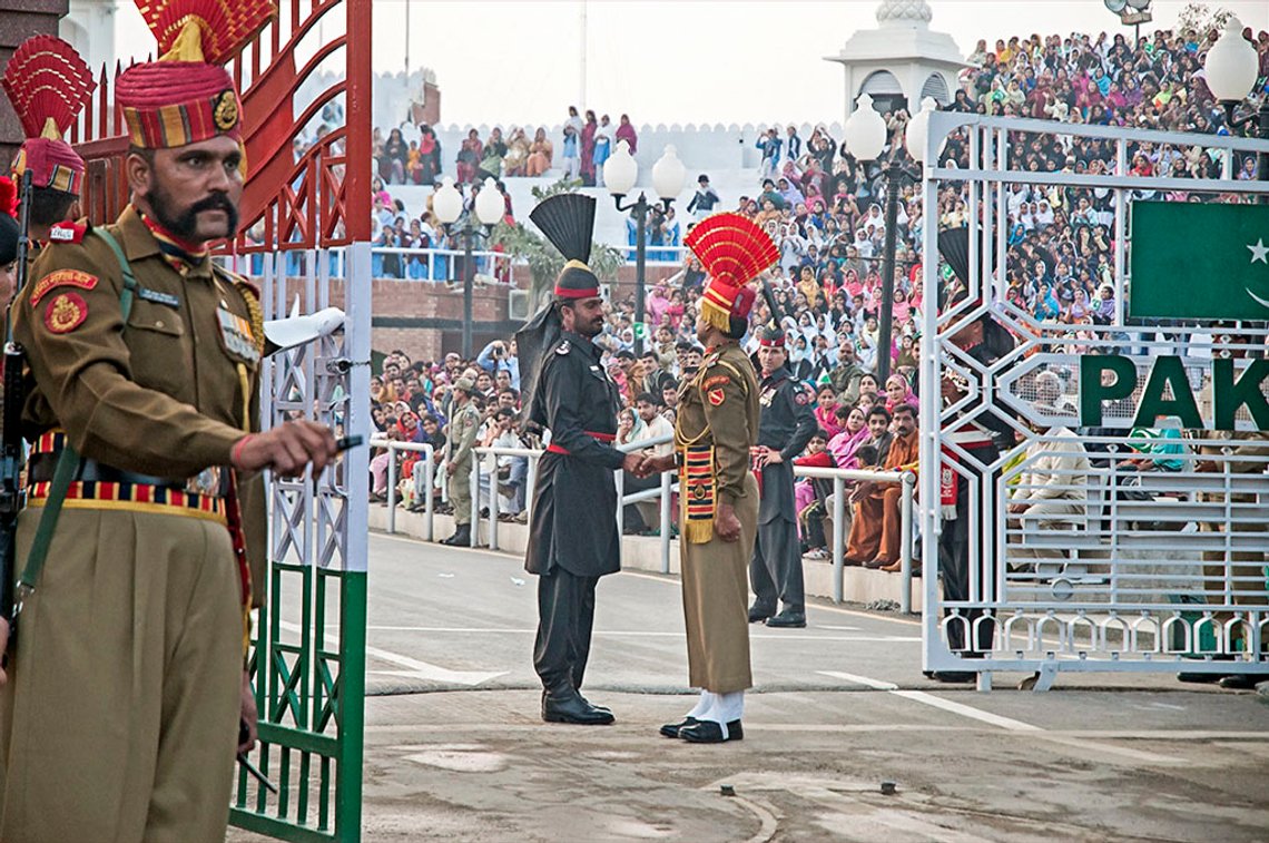 Hver kveld når solen går ned, utfører Indias Border Security Force og Pakistans Rangers en perfekt koordinert seremoni når de senker flagget og lukker porten ved grenseovergangen Wagah-Attari. Tusenvis strømmer til på begge sider for å overvære seremonien som er kjent for å grense til det farseaktige. Dette blir det ikke mere av så lenge grensen er stengt. Foto: Koshy Koshy CC BY 2.0
Lite bilde under, foto: Callaway d1nonly1 Hver kveld når solen går ned, utfører Indias Border Security Force og Pakistans Rangers en perfekt koordinert seremoni når de senker flagget og lukker porten ved grenseovergangen Wagah-Attari. Tusenvis strømmer til på begge sider for å overvære seremonien som er kjent for å grense til det farseaktige. Dette blir det ikke mere av så lenge grensen er stengt. Foto: Koshy Koshy CC BY 2.0
Lite bilde under, foto: Callaway d1nonly1