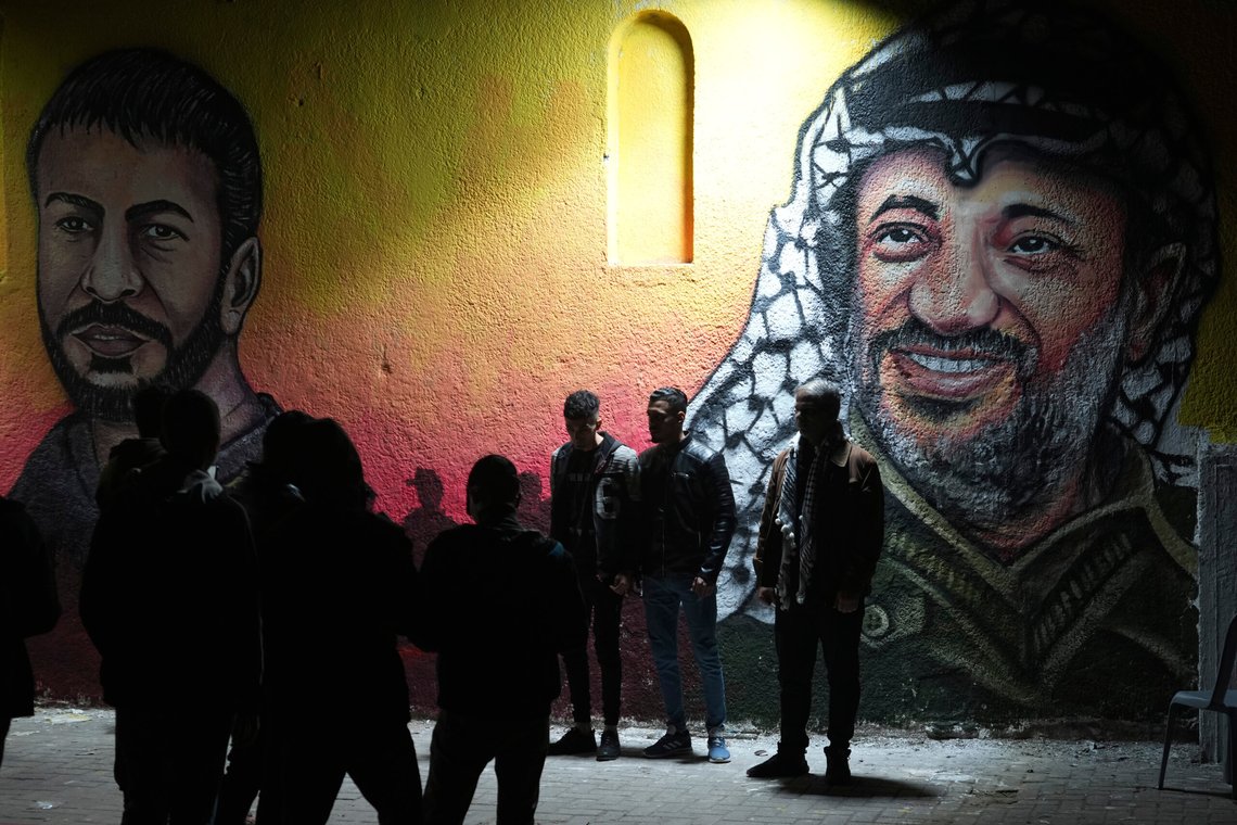 Palestinians take photos of themselves in front of a mural painting of the late Palestinian president Yasser Arafat, right, and late Nasser Abu Hamid, left, a veteran Palestinian prisoner who died from lung cancer in Israeli custody, in preparation of celebration of 58th Fatah anniversary, at the main square in Gaza City, Friday, Dec. 30, 2022. (AP Photo/Adel Hana) Palestinians take photos of themselves in front of a mural painting of the late Palestinian president Yasser Arafat, right, and late Nasser Abu Hamid, left, a veteran Palestinian prisoner who died from lung cancer in Israeli custody, in preparation of celebration of 58th Fatah anniversary, at the main square in Gaza City, Friday, Dec. 30, 2022. (AP Photo/Adel Hana)