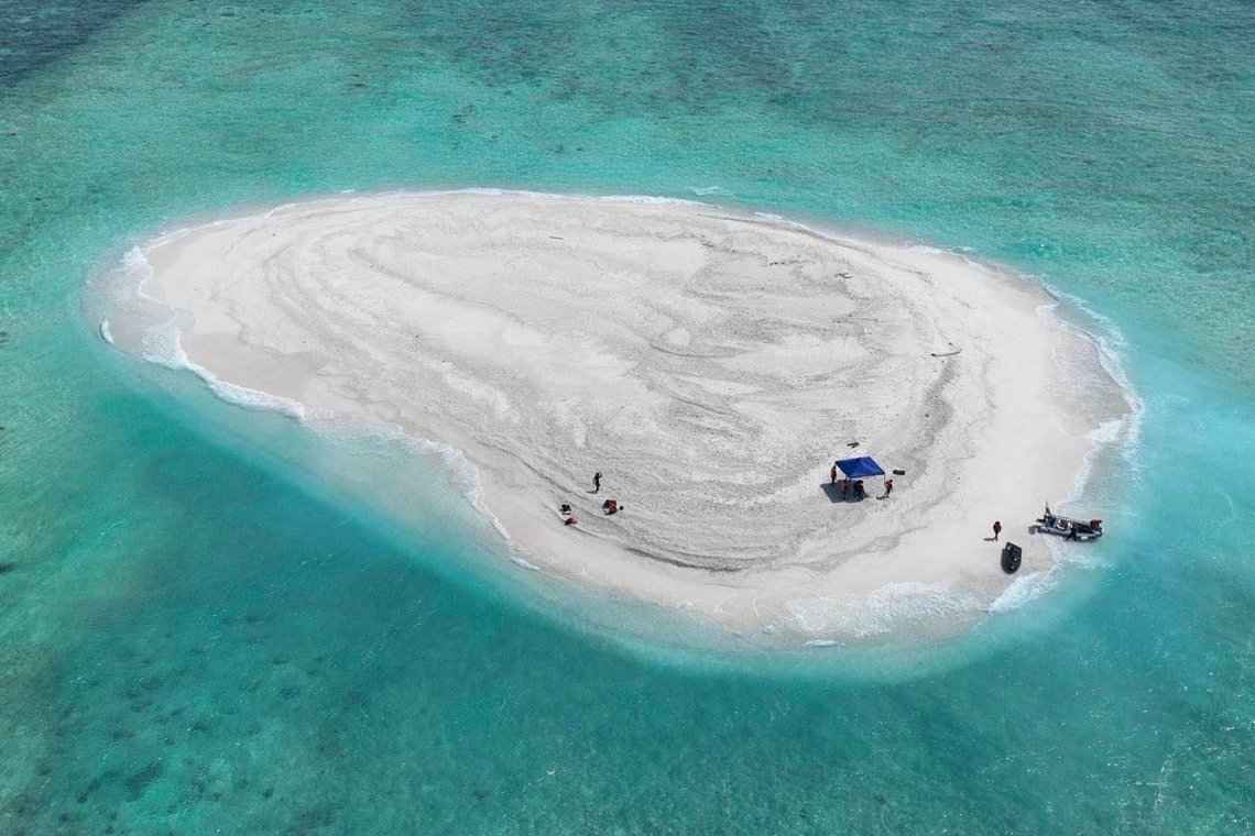 In this photo provided by the Philippine Coast Guard, Filipino scientists reach sandbars called Sandy Cay at the disputed South China Sea on Thursday March 21, 2024. Chinese coast guard ships, backed by a military helicopter, tried to dangerously block but failed to stop two Philippine government vessels carrying scientists from reaching two barren sandbars called Sandy Cay in the disputed South China Sea, Philippine officials said Friday. (Philippine Coast Guard via AP) In this photo provided by the Philippine Coast Guard, Filipino scientists reach sandbars called Sandy Cay at the disputed South China Sea on Thursday March 21, 2024. Chinese coast guard ships, backed by a military helicopter, tried to dangerously block but failed to stop two Philippine government vessels carrying scientists from reaching two barren sandbars called Sandy Cay in the disputed South China Sea, Philippine officials said Friday. (Philippine Coast Guard via AP)
