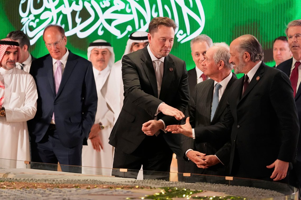 Elon Musk, center, shakes hands with Secretary of Commerce Howard Lutnick, right, as they look at a model of a city under construction, Tuesday, May 13, 2025, in Riyadh, Saudi Arabia. (AP Photo/Alex Brandon) Elon Musk, center, shakes hands with Secretary of Commerce Howard Lutnick, right, as they look at a model of a city under construction, Tuesday, May 13, 2025, in Riyadh, Saudi Arabia. (AP Photo/Alex Brandon)