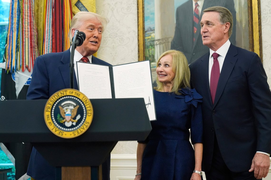 President Donald Trump holds a proclamation regarding VE Day before David Perdue is sworn in as U.S. Ambassador to China during a ceremony in the Oval Office of the White House, Wednesday, May 7, 2025, in Washington. At center is Bonnie Perdue. (AP Photo/Mark Schiefelbein) President Donald Trump holds a proclamation regarding VE Day before David Perdue is sworn in as U.S. Ambassador to China during a ceremony in the Oval Office of the White House, Wednesday, May 7, 2025, in Washington. At center is Bonnie Perdue. (AP Photo/Mark Schiefelbein)
