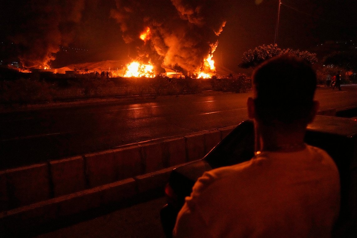 En mann ser på flammer som stiger til værs fra et brennende oljelager etter et israelsk angrep i Teheran natt til søndag. Foto: Vahid Salemi / AP / NTB En mann ser på flammer som stiger til værs fra et brennende oljelager etter et israelsk angrep i Teheran natt til søndag. Foto: Vahid Salemi / AP / NTB