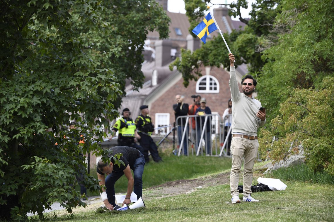 Salwan Momika vifter med det svenske flagget utenfor den irakiske ambassaden i Stockholm 20. juli 2023, hvor han planla å brenne et eksemplar av koranen. Foto: Oscar Olsson, AP-NTB. Salwan Momika vifter med det svenske flagget utenfor den irakiske ambassaden i Stockholm 20. juli 2023, hvor han planla å brenne et eksemplar av koranen. Foto: Oscar Olsson, AP-NTB.
