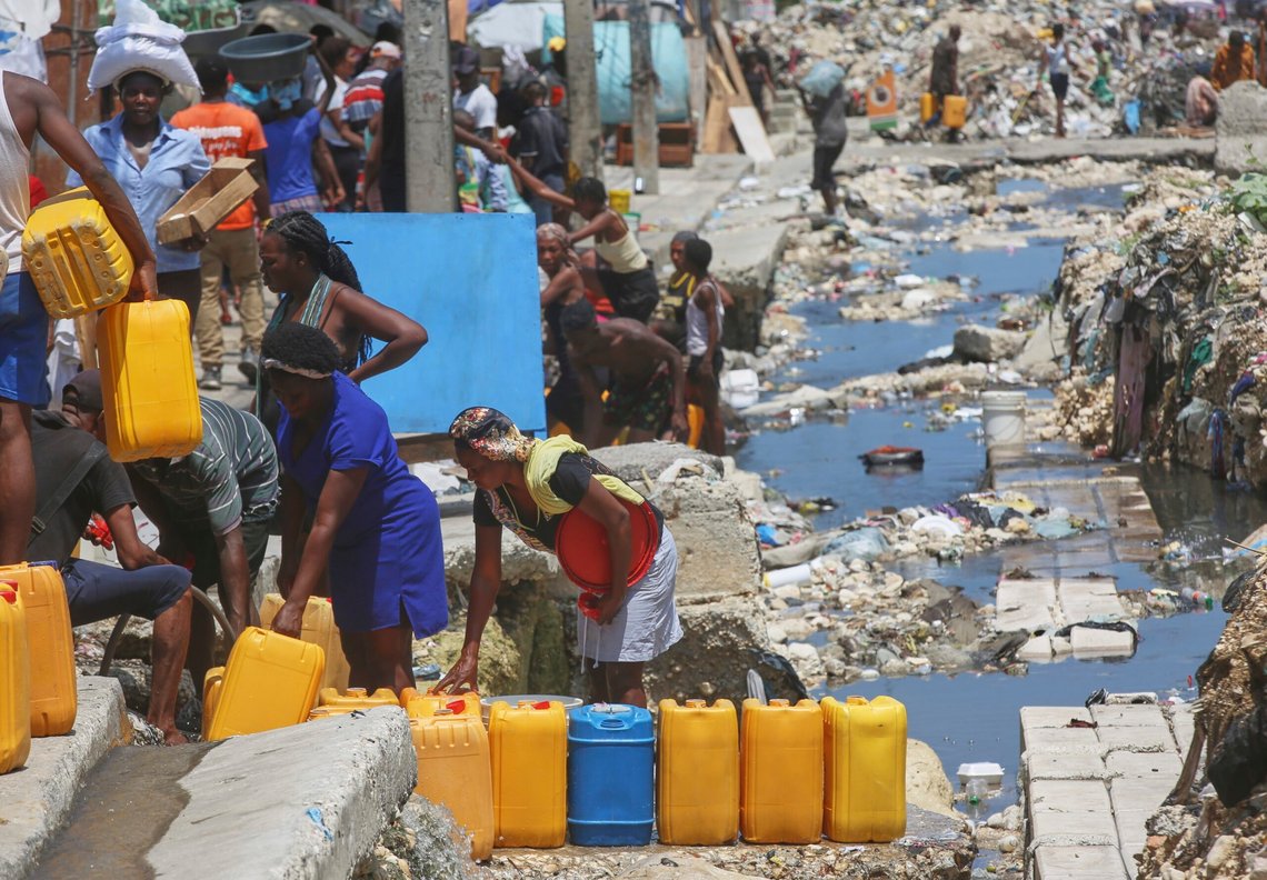 Folk venter på å fylle beholderne sine med drikkevann fra ødelagte underjordiske rør i Port-au-Prince, Haiti, 9. mai 2025. Foto: Odelyn Joseph, AP-NTB. Folk venter på å fylle beholderne sine med drikkevann fra ødelagte underjordiske rør i Port-au-Prince, Haiti, 9. mai 2025. Foto: Odelyn Joseph, AP-NTB.