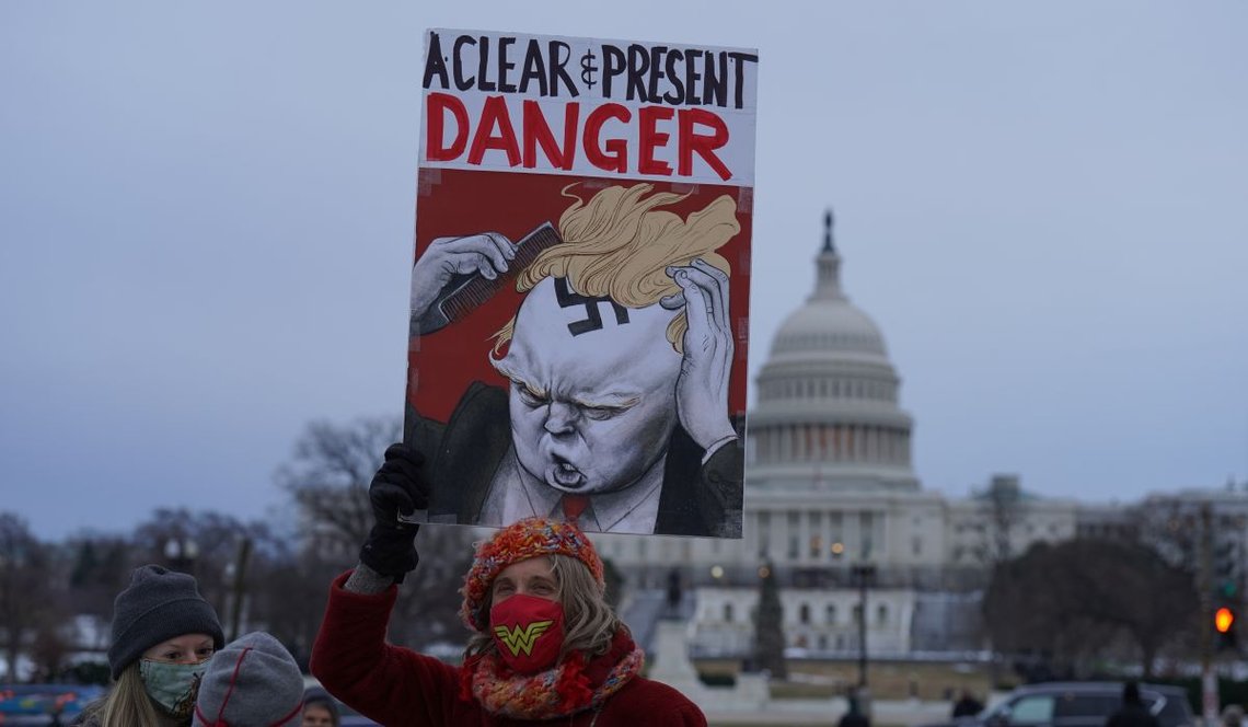 Washington, DC – 6. januar 2022: Demonstranter holder opp plakater med bilder av tidligere president Trump under en demonstrasjon for å bevare demokratiet på National Mall. Foto: Shutterstock av Phil Pasquini. Washington, DC – 6. januar 2022: Demonstranter holder opp plakater med bilder av tidligere president Trump under en demonstrasjon for å bevare demokratiet på National Mall. Foto: Shutterstock av Phil Pasquini.