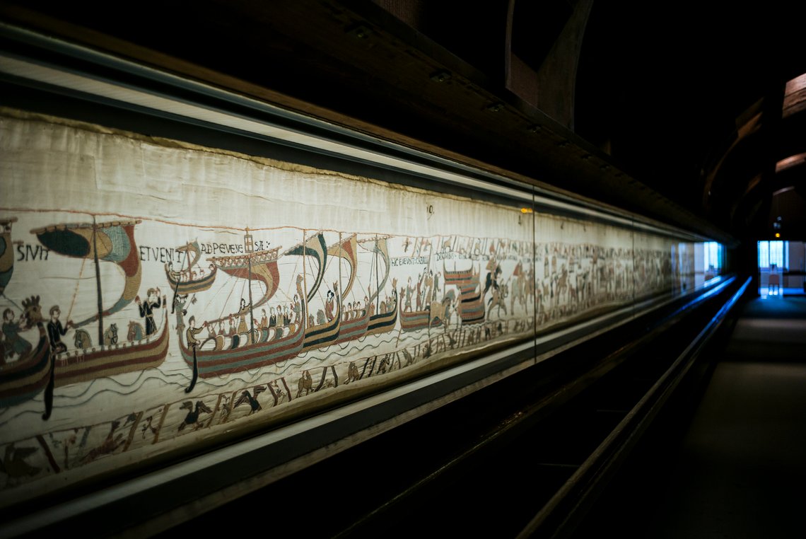 Dette bildet er tatt 18. september 2019 og viser Bayeuxteppet fra det 11. århundre, som forteller om normannernes erobring av England, i Bayeux i Normandie i Frankrike. Foto: Kamil Zihnioglu, AP-NTB. Dette bildet er tatt 18. september 2019 og viser Bayeuxteppet fra det 11. århundre, som forteller om normannernes erobring av England, i Bayeux i Normandie i Frankrike. Foto: Kamil Zihnioglu, AP-NTB.