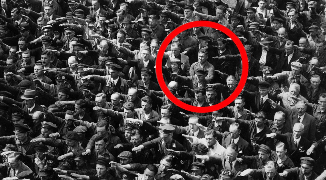 En ukjent person, muligens verftsarbeideren August Landmesser, nekter å gjøre nazi-hilsen i Hamburg den 13. juni 1936. Ukjent opphavsmann. Foto: arastiralim.net via Wikimedia Commons. En ukjent person, muligens verftsarbeideren August Landmesser, nekter å gjøre nazi-hilsen i Hamburg den 13. juni 1936. Ukjent opphavsmann. Foto: arastiralim.net via Wikimedia Commons.