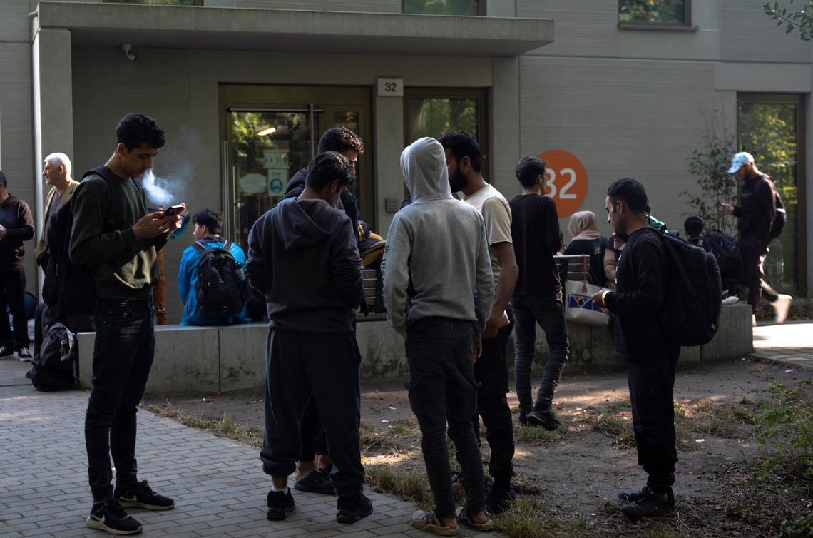 Flere titalls mennesker fra hele verden står i kø foran det sentrale registreringssenteret for asylsøkere i Berlin, Tyskland, mandag 25. september 2023. Rundt om i Tyskland slår myndighetene alarm om at de ikke lenger er i stand til å ta imot migranter som søker om asyl. Foto: AP/Markus Schreiber Flere titalls mennesker fra hele verden står i kø foran det sentrale registreringssenteret for asylsøkere i Berlin, Tyskland, mandag 25. september 2023. Rundt om i Tyskland slår myndighetene alarm om at de ikke lenger er i stand til å ta imot migranter som søker om asyl. Foto: AP/Markus Schreiber