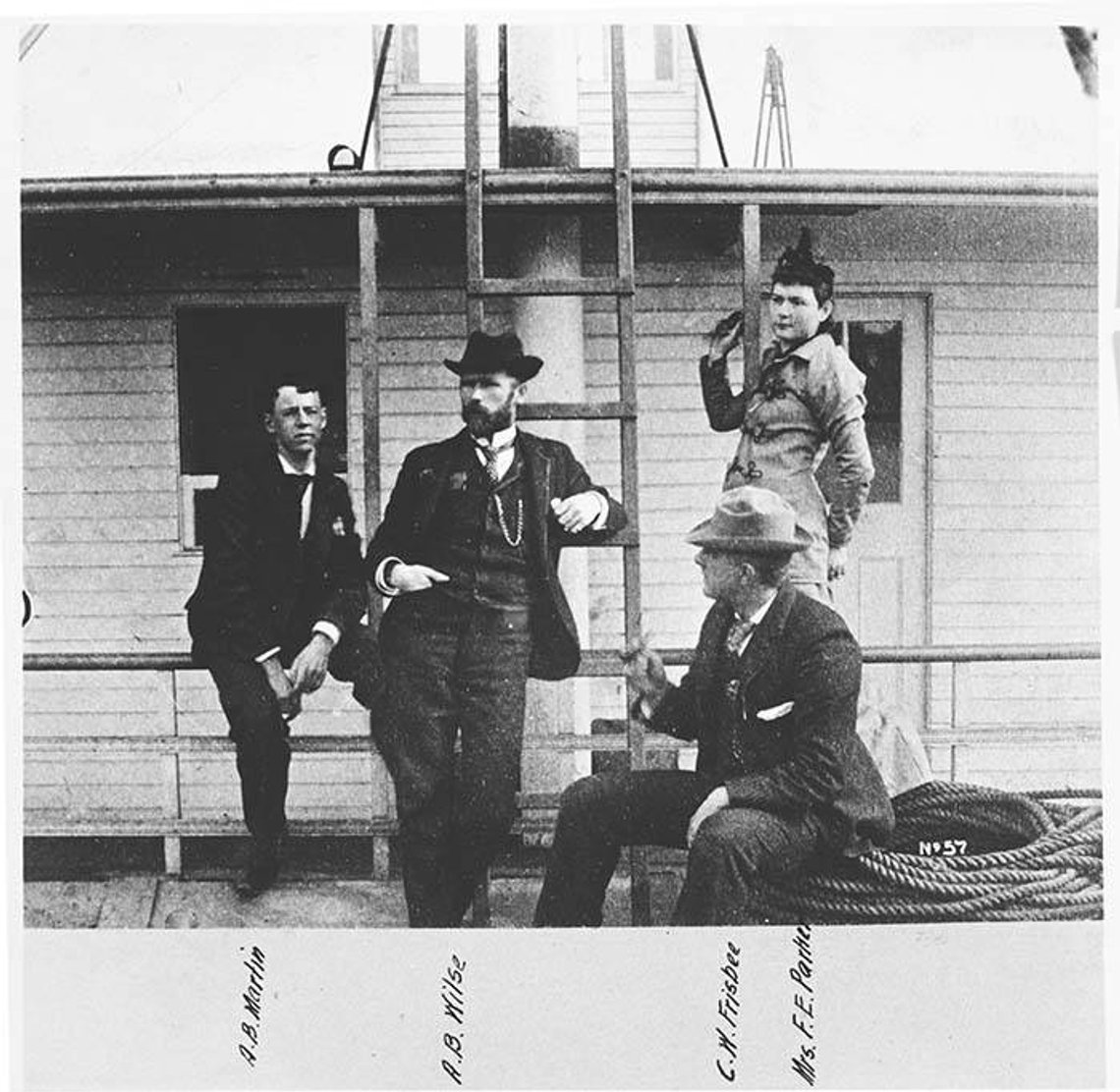Anders Beer Wilse (1865–1949) emigrerte fra Norge i 1884, og ankom Seattle i 1890 for å arbeide for United States Geological Survey. Fotografiet var en viktig del av hans forskjellige jobber som sivilingeniør, kartograf og eiendomsskattvurderer. I 1897 bestemte han seg imidlertid for å bli fulltids friluftsfotograf. Frem til han returnerte til Norge i 1900 tok Wilse mange fotografier i og rundt Seattle, og dokumenterte både områdets natur og travle byliv i den voksende byen.
På dette bildet, tatt rundt 1900, ser vi Wilse (nest til venstre) posere sammen med, fra venstre, A. B. Martin, C. W. Frisbee (sannsynligvis William Wallace Frisbee, 1854–1918) og fru F. E. Parker. De ser ut til å befinne seg på en båt eller kai. Foto: Wikimedia Commons Anders Beer Wilse (1865–1949) emigrerte fra Norge i 1884, og ankom Seattle i 1890 for å arbeide for United States Geological Survey. Fotografiet var en viktig del av hans forskjellige jobber som sivilingeniør, kartograf og eiendomsskattvurderer. I 1897 bestemte han seg imidlertid for å bli fulltids friluftsfotograf. Frem til han returnerte til Norge i 1900 tok Wilse mange fotografier i og rundt Seattle, og dokumenterte både områdets natur og travle byliv i den voksende byen.
På dette bildet, tatt rundt 1900, ser vi Wilse (nest til venstre) posere sammen med, fra venstre, A. B. Martin, C. W. Frisbee (sannsynligvis William Wallace Frisbee, 1854–1918) og fru F. E. Parker. De ser ut til å befinne seg på en båt eller kai. Foto: Wikimedia Commons