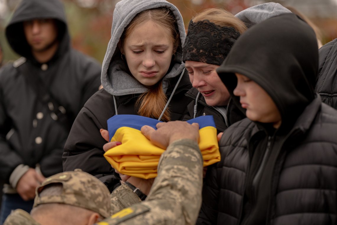 A serviceman hands a folded Ukrainian flag to Mariia Pyvovar, 32, wife of soldier Oleh Pyvovar, who was killed at a combat mission in the Donetsk region, during a funeral, in Irpin, Ukraine, Wednesday, Oct. 15, 2025. (AP Photo/Julia Demaree Nikhinson) A serviceman hands a folded Ukrainian flag to Mariia Pyvovar, 32, wife of soldier Oleh Pyvovar, who was killed at a combat mission in the Donetsk region, during a funeral, in Irpin, Ukraine, Wednesday, Oct. 15, 2025. (AP Photo/Julia Demaree Nikhinson)