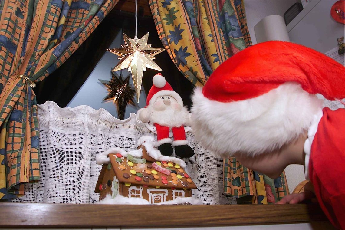 Jul med din glede... En liten julenisse kikker på et fristende pepperkakehus. Julestjerne og julenisse gjør julestemningen fullkommen. Foto: NTB Jul med din glede... En liten julenisse kikker på et fristende pepperkakehus. Julestjerne og julenisse gjør julestemningen fullkommen. Foto: NTB