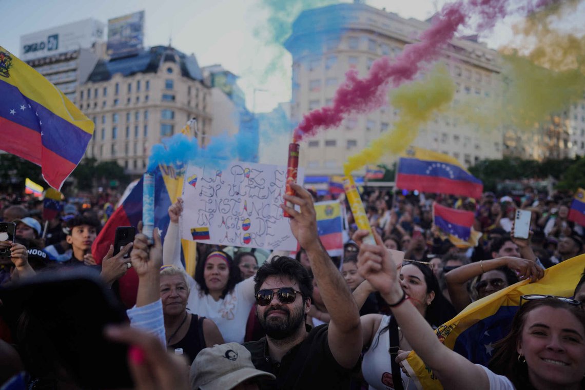 Venezuelanere i Buenos Aires feirer den 3. januar 2026 etter Donald Trumps kunngjøring om at Venezuelas president Nicolas Maduro er tatt til fange. Foto: Natacha Pisarenko / AP / NTB. Venezuelanere i Buenos Aires feirer den 3. januar 2026 etter Donald Trumps kunngjøring om at Venezuelas president Nicolas Maduro er tatt til fange. Foto: Natacha Pisarenko / AP / NTB.
