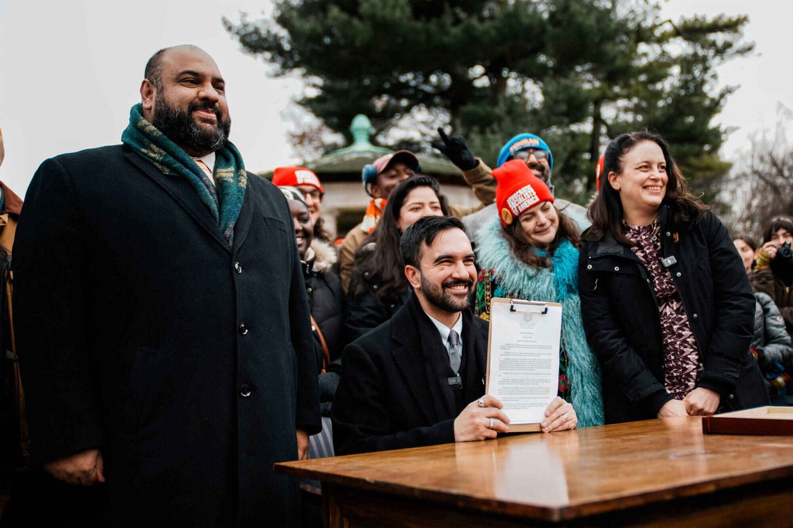 New York City Mayor Zohran Mamdani, center, joined by Ali Najmi, left, chair of the Mayor's Advisory Committee on the Judiciary, and Tascha Van Auken, right, commissioner of the Mayor's Office of Mass Engagement, holds up a signed executive order during a press conference in New York, Friday, Jan. 2, 2026. (AP Photo/Eduardo Munoz Alvarez) New York City Mayor Zohran Mamdani, center, joined by Ali Najmi, left, chair of the Mayor's Advisory Committee on the Judiciary, and Tascha Van Auken, right, commissioner of the Mayor's Office of Mass Engagement, holds up a signed executive order during a press conference in New York, Friday, Jan. 2, 2026. (AP Photo/Eduardo Munoz Alvarez)