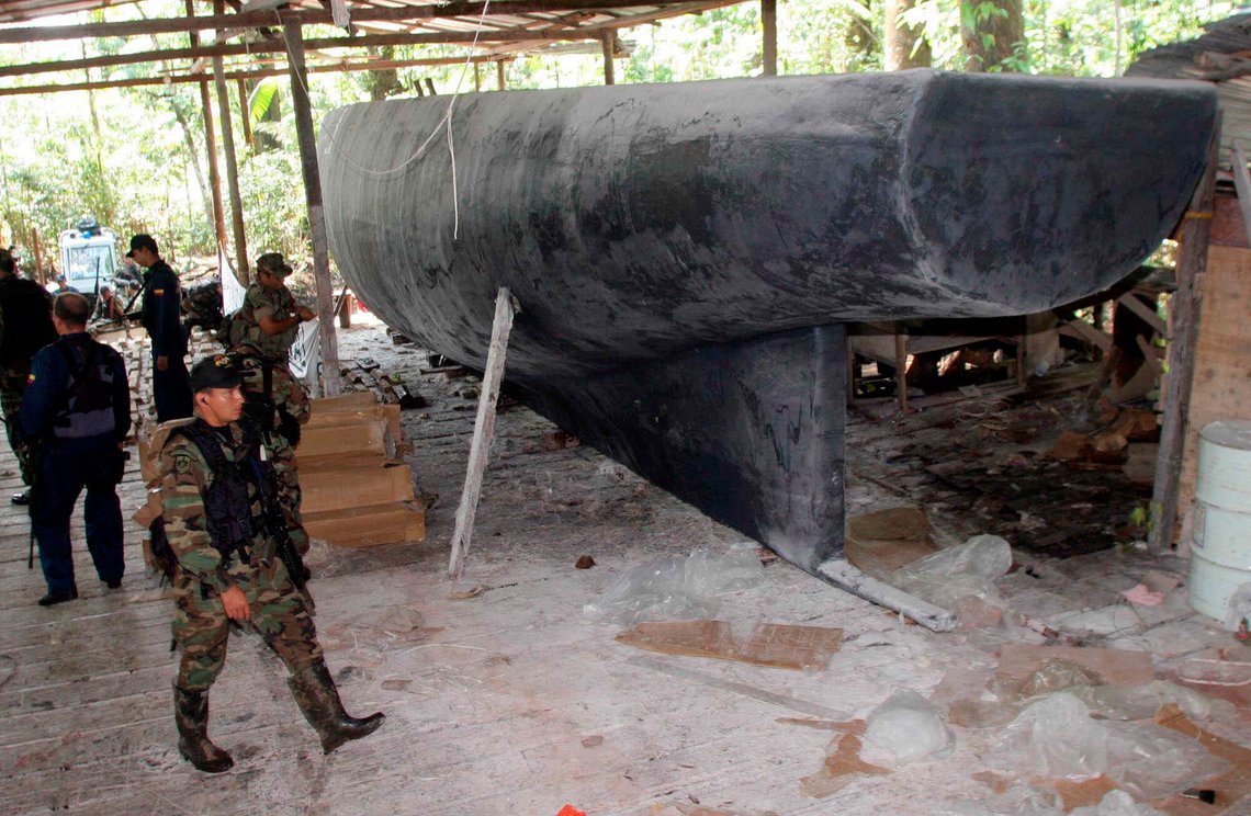 Colombian marines inspect a fiberglass submarine that was been built by drug traffickers to transport drugs in Salaonda, on the Pacific Ocean, some 370 miles southwest of Bogota, Saturday, March 26, 2005. Authorities said the vessel would have been used to ferry cocaine to speed boats offshore, which would then take the drugs to Central America or Mexico, for eventual delivery to the United States. (AP Photo/Inaldo Perez) **EFE OUT** Colombian marines inspect a fiberglass submarine that was been built by drug traffickers to transport drugs in Salaonda, on the Pacific Ocean, some 370 miles southwest of Bogota, Saturday, March 26, 2005. Authorities said the vessel would have been used to ferry cocaine to speed boats offshore, which would then take the drugs to Central America or Mexico, for eventual delivery to the United States. (AP Photo/Inaldo Perez) **EFE OUT**