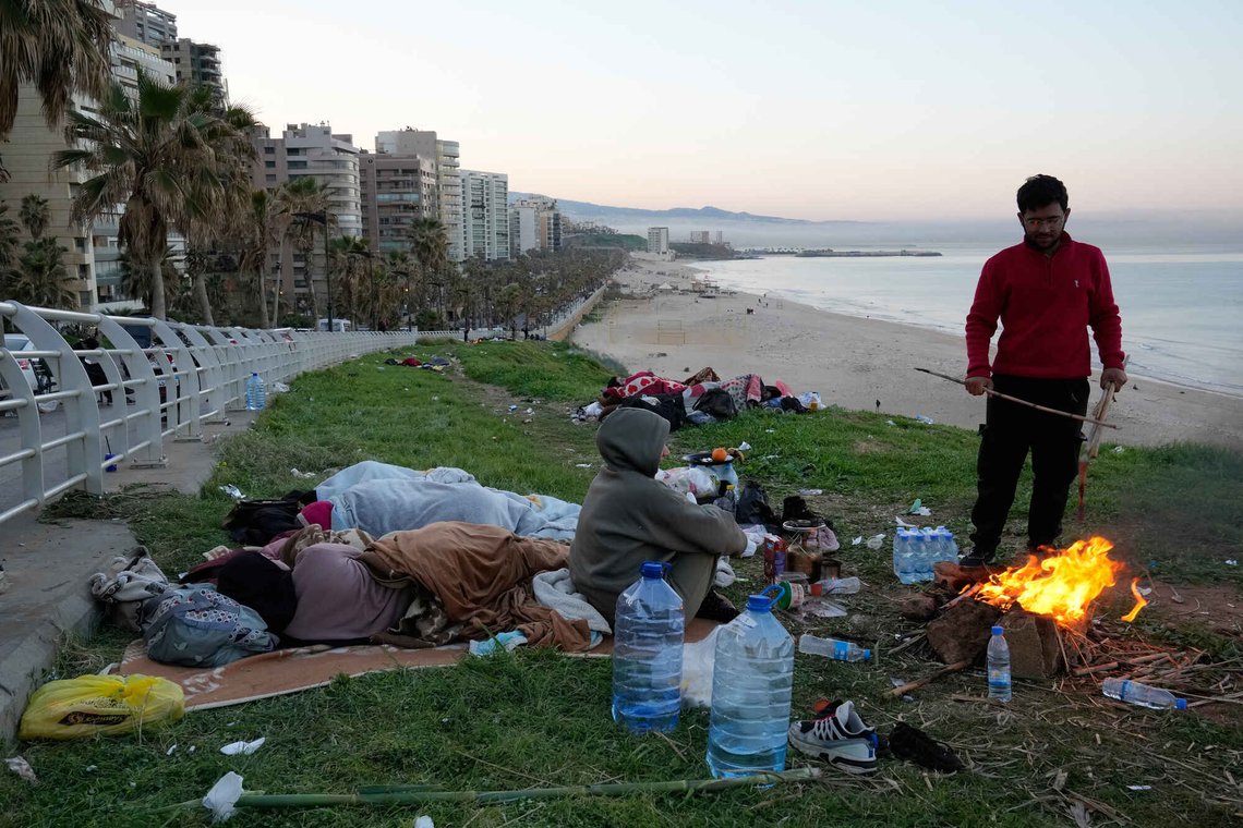 A displaced man with his family fleeing Israeli airstrikes in Beirut's southern suburb of Dahiyeh sets fire to warm themselves on the Beirut corniche, Lebanon, Friday, March 6, 2026. (AP Photo/Hussein Malla) A displaced man with his family fleeing Israeli airstrikes in Beirut's southern suburb of Dahiyeh sets fire to warm themselves on the Beirut corniche, Lebanon, Friday, March 6, 2026. (AP Photo/Hussein Malla)