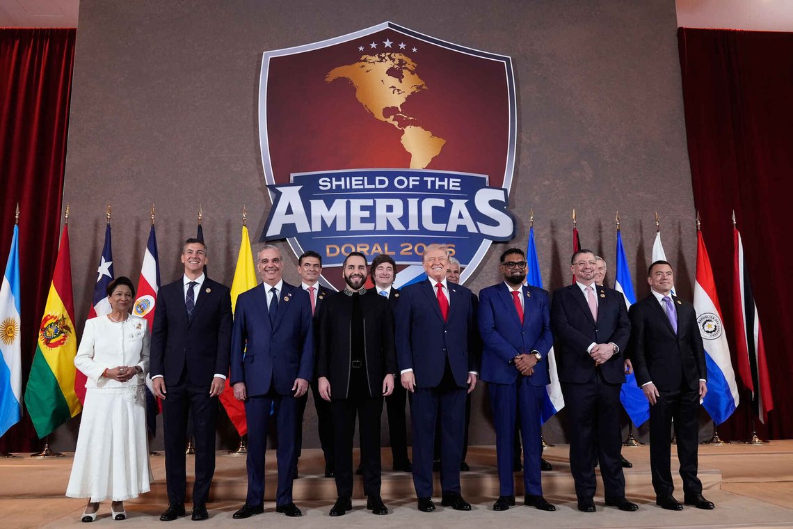 Gruppebilde fra Shield of the Americas toppmøte, lør. 7. mars, 2026, ved Trump National Doral Miami i Florida. Forrest fra venstre: Trinidad og Tobagos statsminister Kamla Persad-Bissessar, Paraguays president Santiago Pena, Den Dominikanske Republikks president Luis Abinader, El Salvadors president Nayib Bukele, President Donald Trump, Guyanas president Mohamed Irfaan Ali, Costa Ricas president Rodrigo Chaves Robles, Ecuadors president Daniel Noboa. Bakerst fra venstre: Bolivias president Rodrigo Paz Pereira, Argentinas president Javier Milei, Panamas president José Raúl Mulino, Honduras president Nasry Asfura (ikke synlig), og Chiles påtroppende president Jose Antonio Kast (delvis synlig). (AP Photo/Mark Schiefelbein) Gruppebilde fra Shield of the Americas toppmøte, lør. 7. mars, 2026, ved Trump National Doral Miami i Florida. Forrest fra venstre: Trinidad og Tobagos statsminister Kamla Persad-Bissessar, Paraguays president Santiago Pena, Den Dominikanske Republikks president Luis Abinader, El Salvadors president Nayib Bukele, President Donald Trump, Guyanas president Mohamed Irfaan Ali, Costa Ricas president Rodrigo Chaves Robles, Ecuadors president Daniel Noboa. Bakerst fra venstre: Bolivias president Rodrigo Paz Pereira, Argentinas president Javier Milei, Panamas president José Raúl Mulino, Honduras president Nasry Asfura (ikke synlig), og Chiles påtroppende president Jose Antonio Kast (delvis synlig). (AP Photo/Mark Schiefelbein)