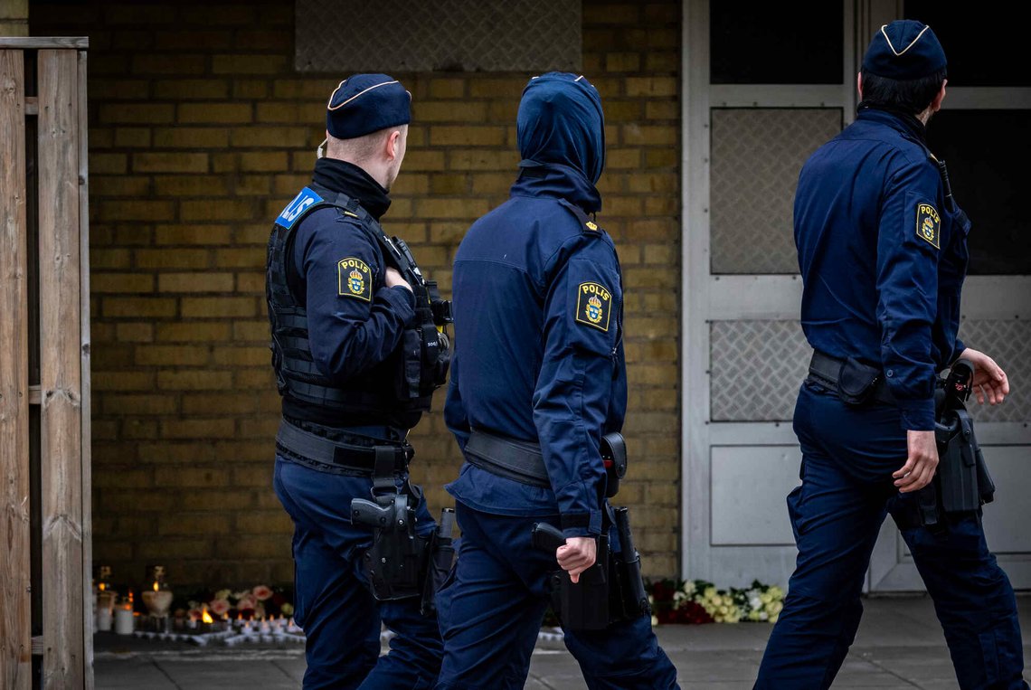 Politibetjenter på patrulje passerer torsdag minnestedet med lys og blomster i porten der en 15 år gammel gutt ble skutt og drept i Rosengård onsdag kveld. Foto: Johan Nilsson, TT-NTB. Politibetjenter på patrulje passerer torsdag minnestedet med lys og blomster i porten der en 15 år gammel gutt ble skutt og drept i Rosengård onsdag kveld. Foto: Johan Nilsson, TT-NTB.