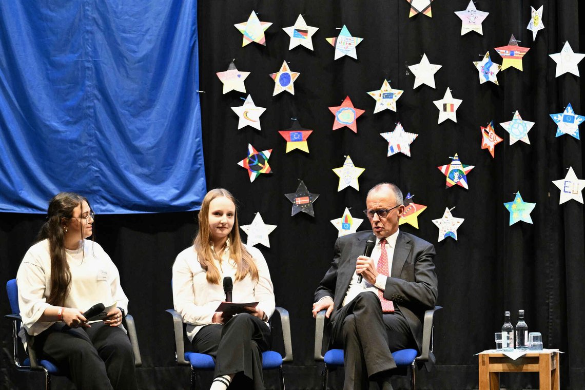 Germany's Chancellor Friedrich Merz, right, takes part in a panel discussion with pupils on European issues, during a visit to Carolus-Magnus-Gymnasium, in Marsberg, Germany, Monday, April 27, 2026. (Federico Gambarini/dpa via AP) Germany's Chancellor Friedrich Merz, right, takes part in a panel discussion with pupils on European issues, during a visit to Carolus-Magnus-Gymnasium, in Marsberg, Germany, Monday, April 27, 2026. (Federico Gambarini/dpa via AP)