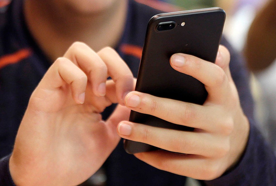FILE - In this Sept. 16, 2017, file photo, a person uses a smart phone in Chicago. The next time you check your DMs, you could see a message from a debt collector. Late last year, the Consumer Financial Protection Bureau rolled out new rules that allow debt collectors to contact debtors through social media. (AP Photo, File) FILE - In this Sept. 16, 2017, file photo, a person uses a smart phone in Chicago. The next time you check your DMs, you could see a message from a debt collector. Late last year, the Consumer Financial Protection Bureau rolled out new rules that allow debt collectors to contact debtors through social media. (AP Photo, File)