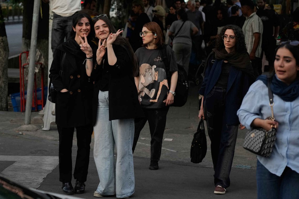 Women react to the camera as they wait for a green light for pedestrians in an intersection in downtown Tehran, Iran, Tuesday, May 12, 2026. (AP Photo/Vahid Salemi) Women react to the camera as they wait for a green light for pedestrians in an intersection in downtown Tehran, Iran, Tuesday, May 12, 2026. (AP Photo/Vahid Salemi)