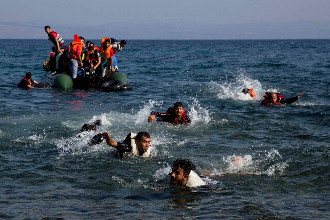FILE - Migrants, whose boat stalled while crossing from Turkey to Greece, swim to the island of Lesbos, Greece, on Sept. 20, 2015. (AP Photo/Petros Giannakouris, File) FILE - Migrants, whose boat stalled while crossing from Turkey to Greece, swim to the island of Lesbos, Greece, on Sept. 20, 2015. (AP Photo/Petros Giannakouris, File)