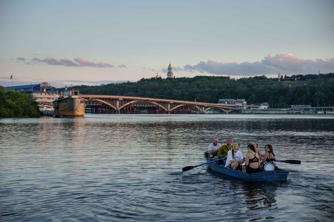 Selv i et krigsrammet land som Ukraina er hetebølgen dagens nyheter. Bildet viser en gruppe mennesker på vei over elven Dnipro ved Kyiv torsdag i forrige uke. Samtidig ble byen utsatt for et russisk angrep. Foto: Evgenyj Maloletka / AP / NTB Selv i et krigsrammet land som Ukraina er hetebølgen dagens nyheter. Bildet viser en gruppe mennesker på vei over elven Dnipro ved Kyiv torsdag i forrige uke. Samtidig ble byen utsatt for et russisk angrep. Foto: Evgenyj Maloletka / AP / NTB