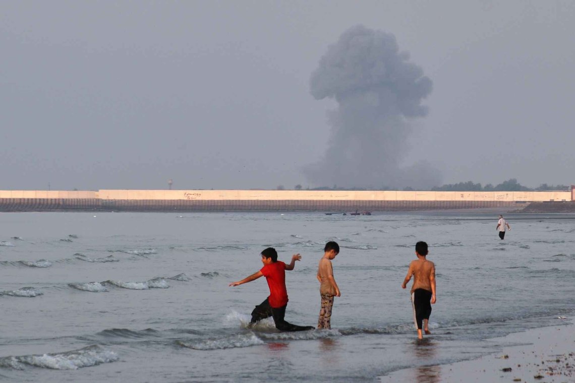 Tre gutter leker i det grunne vannet i Hormuzstredet, og lar seg ikke skremme av en eksplosjon i bakgrunnen. Bildet er tatt utenfor Bandar Abbas i Iran, mandag 13. juli. Foto: Razieh Poudat /ISNA via AP/ NTB Tre gutter leker i det grunne vannet i Hormuzstredet, og lar seg ikke skremme av en eksplosjon i bakgrunnen. Bildet er tatt utenfor Bandar Abbas i Iran, mandag 13. juli. Foto: Razieh Poudat /ISNA via AP/ NTB