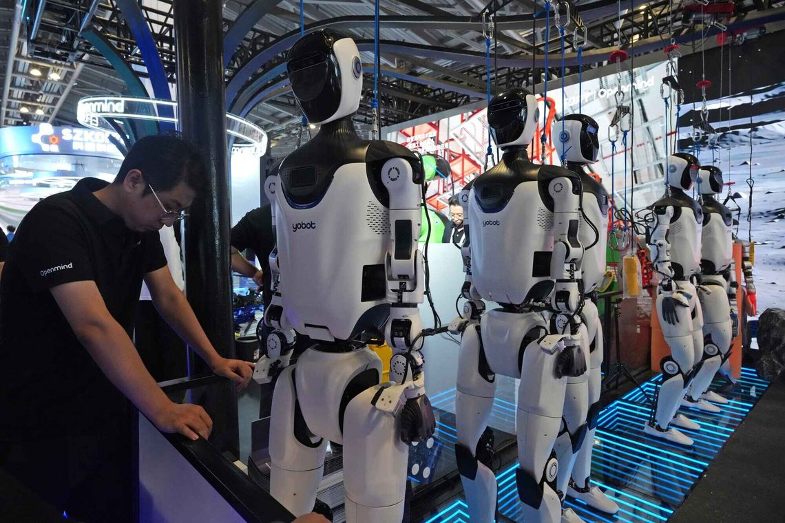 En arbeider bivåner humanoide roboter som vises frem på World AI Conference i Shanghai den 17. juli 2026. Foto: Ng Han Guan / AP / NTB. En arbeider bivåner humanoide roboter som vises frem på World AI Conference i Shanghai den 17. juli 2026. Foto: Ng Han Guan / AP / NTB.