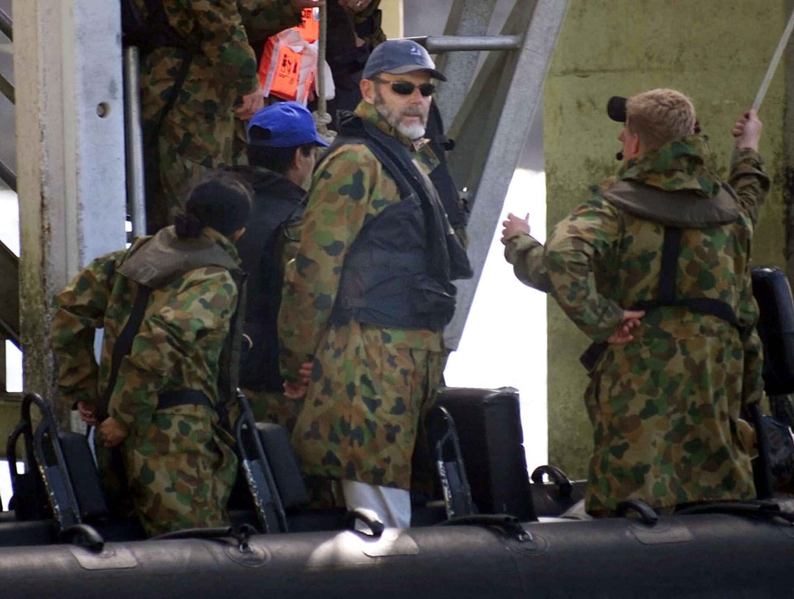 Norwegian Ambassador to Australia Ove Thorsheim, center, stands on a rubber boat as members of The Australian Army's Special Air Services (SAS) commandos help other officials to get on board, prior to their visit to "Tampa" freighter at Christmas Island port in Christmas Island, Australia, Sunday, Sept. 2, 2001. The ship is carrying 438 refugees and has been banned from docking on the island because of fears by Australian government that more illegal migrants will enter the country. (AP Photo/Dita Alangkara) Norwegian Ambassador to Australia Ove Thorsheim, center, stands on a rubber boat as members of The Australian Army's Special Air Services (SAS) commandos help other officials to get on board, prior to their visit to "Tampa" freighter at Christmas Island port in Christmas Island, Australia, Sunday, Sept. 2, 2001. The ship is carrying 438 refugees and has been banned from docking on the island because of fears by Australian government that more illegal migrants will enter the country. (AP Photo/Dita Alangkara)