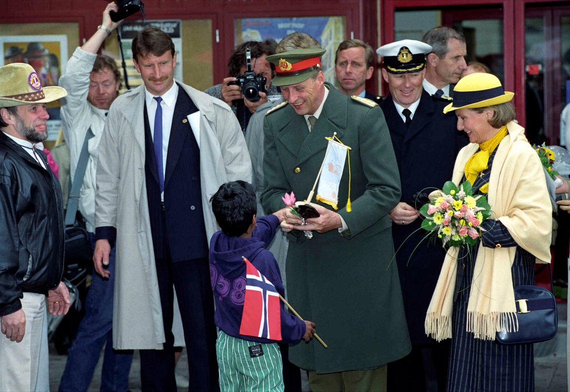 Tynset 19910621: SIGNINGSFERDEN juni 1991. Kong Harald V - signing og signingsferd. Bildet: Omvisning med bredt program
i Kulturhuset. Kongeparet, kong Harald og dronning Sonja. Kongen får en gave fra en liten gutt med norsk flagg. - Dronnning Sonja i gul hatt og gult sjal. - FOTO: Terje Bendiksby Tynset 19910621: SIGNINGSFERDEN juni 1991. Kong Harald V - signing og signingsferd. Bildet: Omvisning med bredt program
i Kulturhuset. Kongeparet, kong Harald og dronning Sonja. Kongen får en gave fra en liten gutt med norsk flagg. - Dronnning Sonja i gul hatt og gult sjal. - FOTO: Terje Bendiksby