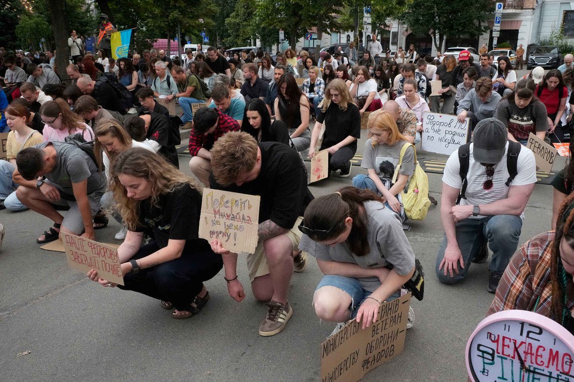 Demonstrators kneel as they take a moment of silence to honour the fallen soldiers in Russia-Ukraine war during a rally to denounce President Volodymyr Zelenskyy's decision to dismiss Defense Minister Mykhailo Fedorov after six months in the post, in Kyiv, Ukraine, Friday, July 24, 2026. (AP Photo/Efrem Lukatsky) Demonstrators kneel as they take a moment of silence to honour the fallen soldiers in Russia-Ukraine war during a rally to denounce President Volodymyr Zelenskyy's decision to dismiss Defense Minister Mykhailo Fedorov after six months in the post, in Kyiv, Ukraine, Friday, July 24, 2026. (AP Photo/Efrem Lukatsky)