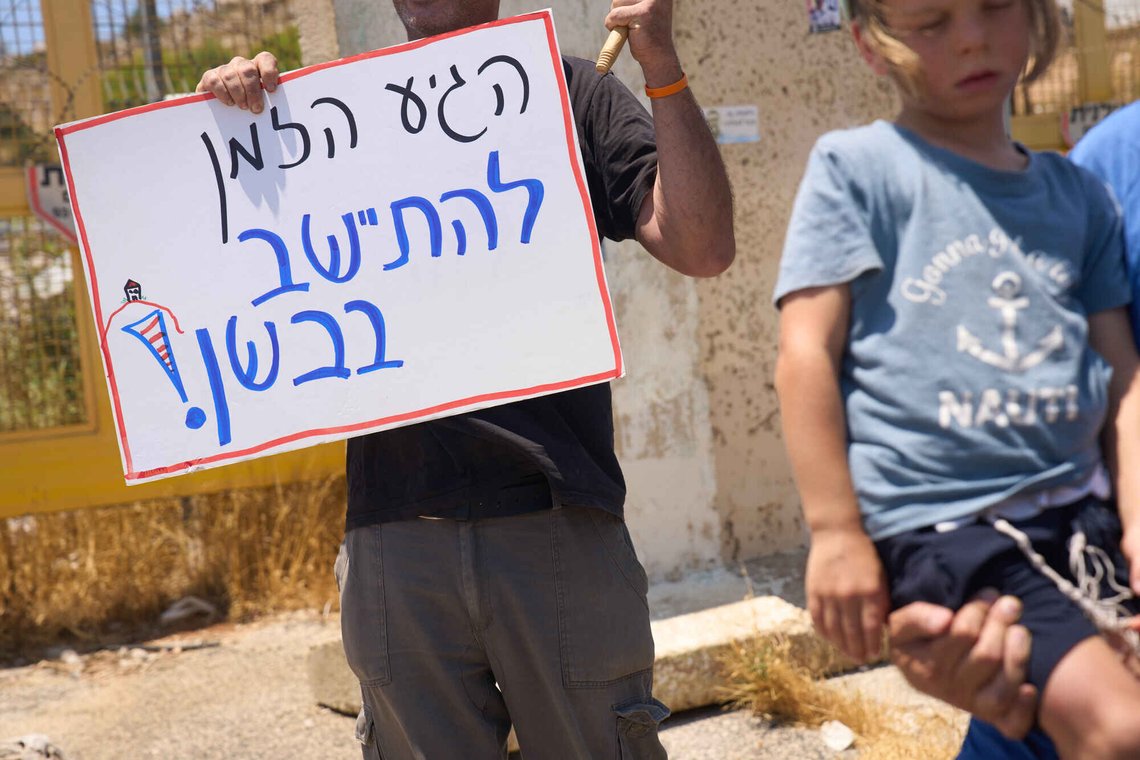A right-wing Israeli activist holds a sign which reads "Its about time to settle in the Bashan", in the Israeli-occupied Golan Heights, Tuesday, July 21, 2026. (AP Photo/Ariel Schalit) A right-wing Israeli activist holds a sign which reads "Its about time to settle in the Bashan", in the Israeli-occupied Golan Heights, Tuesday, July 21, 2026. (AP Photo/Ariel Schalit)