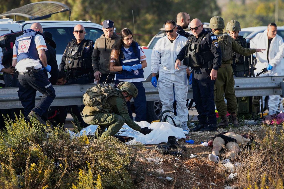 Et tildekket offer og en utildekket terrorist ligger døde på bakken langs en bilvei etter et kombinert påkjørsels- og knivangrep ved Gush Etzion på Vestbredden den 18. november 2025. Foto: Ohad Zwigenberg / AP / NTB. Et tildekket offer og en utildekket terrorist ligger døde på bakken langs en bilvei etter et kombinert påkjørsels- og knivangrep ved Gush Etzion på Vestbredden den 18. november 2025. Foto: Ohad Zwigenberg / AP / NTB.
