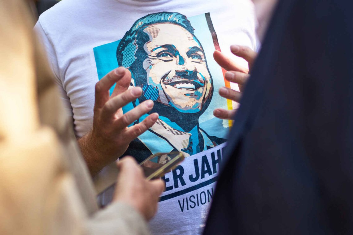 A man speaks to media with a shirt showing Ulrich Sigmund, top candidate of the Alternative for Germany, AfD, party for the federal state elections in Sachsen Anhalt, during at a campaign barbecue hosted by the party in Moeser, Germany, Thursday, Aug. 13, 2026. (AP Photo/Markus Schreiber) A man speaks to media with a shirt showing Ulrich Sigmund, top candidate of the Alternative for Germany, AfD, party for the federal state elections in Sachsen Anhalt, during at a campaign barbecue hosted by the party in Moeser, Germany, Thursday, Aug. 13, 2026. (AP Photo/Markus Schreiber)
