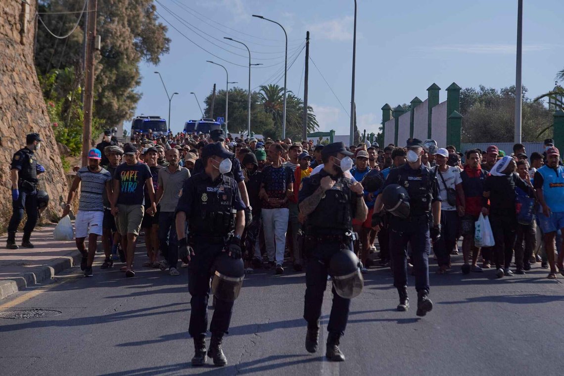 Migranter som krysset grensen fra Marokko til Spania, blir eskortert av spansk politi til midlertidige oppholdssteder etter å ha blitt fjernet fra en strand i den spanske eksklaven Ceuta den 20. august 2026. Foto: Antonio Sempere / AP / NTB. Migranter som krysset grensen fra Marokko til Spania, blir eskortert av spansk politi til midlertidige oppholdssteder etter å ha blitt fjernet fra en strand i den spanske eksklaven Ceuta den 20. august 2026. Foto: Antonio Sempere / AP / NTB.